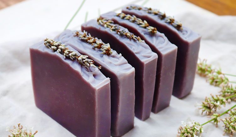 Five lavender color lavender soap blocks stacked in a line